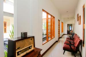 salon z telewizorem i krzesłami w obiekcie S5 Guest House Yogyakarta w mieście Yogyakarta