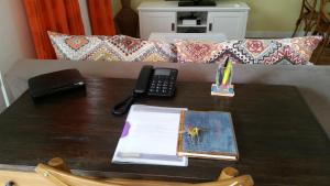a table with a remote control and a telephone on it at Cosy By Mélanie - Un hôtel comme chez vous in Fort-de-France