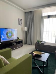 a living room with a couch and a tv at One Bedroom Apartment DAMAC Celestia -EXPO Road in Dubai