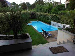a swimming pool with a chair in a yard at Villa Le Lanterne Pool & Relax in Mondello