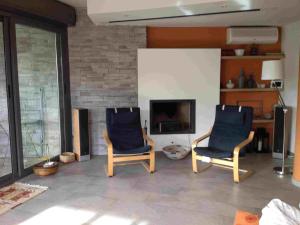 a living room with two chairs and a tv at Villa Le Lanterne Pool & Relax in Mondello