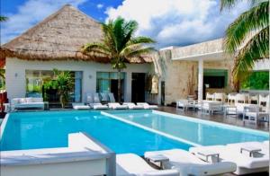 - une piscine avec des chaises longues et un complexe dans l'établissement CondoHotel En Riviera Maya, Playa del Carmen, à Playa del Carmen