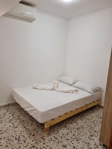 łóżko z białą pościelą i poduszkami w pokoju w obiekcie דירה במדבר w Ejlat