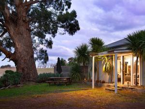 a house with a picnic table and a tree at Minni Gums in Daylesford
