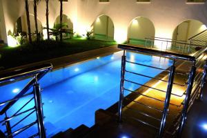 a swimming pool with stairs leading to a building at Ganimede Hotel in Sperlonga