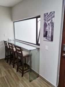 ArandasにあるCasa Arandas Hotel - Suitsの窓付きの客室で、ガラスのテーブルと椅子が備わります。