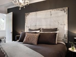 a bedroom with a large bed with a large headboard at The Orchard in Daylesford