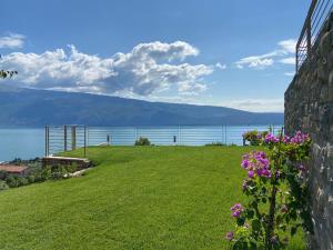 a view of the water from a house with flowers at Relais Zenner in Toscolano Maderno