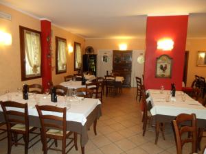a restaurant with white tables and chairs and red walls at Locanda Gallo in Dolo +37 photos