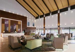 a lobby with tables and chairs in a building at Villea Rompin Resort & Golf in Kuala Rompin