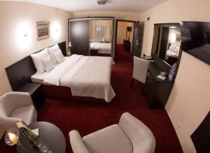 ヴィエリチカにあるHotel Sorayのベッドとリビングルームが備わるホテルルームです。