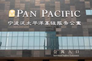 una señal en el lateral de un edificio en Pan Pacific Serviced Suites Ningbo, en Ningbo