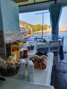 a table with bread and pastries on it next to the water at Clipper Suite in Ischia