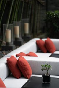 a row of white beds with red pillows on them at The Puli Hotel And Spa in Shanghai