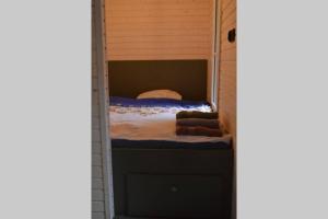 ein Zimmer mit einem Bett in einem kleinen Haus in der Unterkunft heather hut, off-grid cottage on a pond+2 ha in Darżkowo