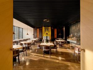 un ristorante con tavoli e sedie in una stanza di The Puli Hotel And Spa a Shanghai