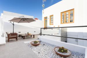 an outdoor patio with a table and an umbrella at Home2Book Spectacular Studio Los Silos, Terrace in Los Silos