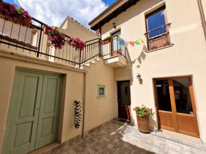 una casa con porta verde e balcone di Il Bivacco del Duomo a L'Aquila