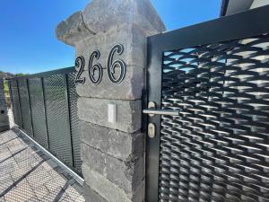 an iron gate with the on it next to a fence at Ubytovanie Kolta 266 in Kolta