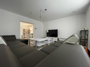 Habitación con sofás, mesa y TV. en Ubytovanie Kolta 266, en Kolta