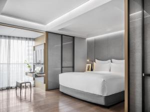 a large white bed in a bedroom at CHAO Sanlitun Beijing in Beijing