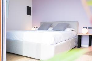 a bedroom with a large white bed with blue pillows at Encanto Agriturismo & Private SPA in Visogliano