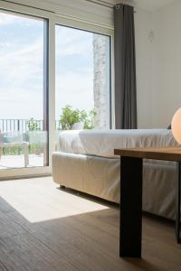 a bedroom with a bed and a large window at Encanto Agriturismo & Private SPA in Visogliano