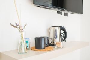 a kitchen counter with two coffee cups and a tv at Encanto Agriturismo & Private SPA in Visogliano