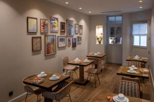 a restaurant with tables and chairs and pictures on the wall at Hôtel du Danube Saint Germain in Paris