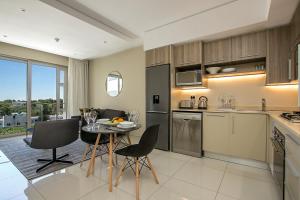 a kitchen and dining room with a table and chairs at The Serviced Apartment Collection At The Tyrwhitt Rosebank in Johannesburg