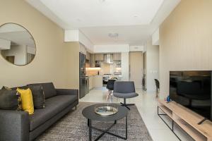 a living room with a couch and a table at The Serviced Apartment Collection At The Tyrwhitt Rosebank in Johannesburg