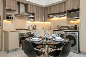 a kitchen with a dining room table and chairs at The Serviced Apartment Collection At The Tyrwhitt Rosebank in Johannesburg