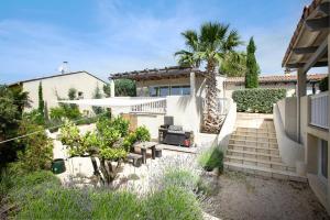 una casa con escaleras y una palmera en La Villa Les Petits Gardons, en Castillon-du-Gard