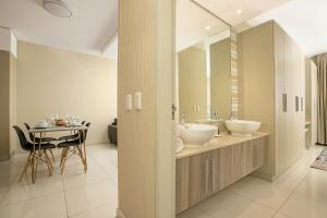 a bathroom with two sinks and a table at The Serviced Apartment Collection At The Tyrwhitt Rosebank in Johannesburg +115 photos