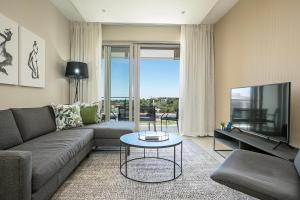 a living room with a couch and a tv at The Serviced Apartment Collection At The Tyrwhitt Rosebank in Johannesburg