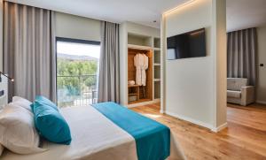 a bedroom with a large bed and a large window at Hotel Boutique Molino de Enmedio in Huéneja