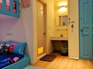una piccola camera con un divano blu e un lavandino di 墾丁舍廷親子會館 KT13 Hotel a Nanwan