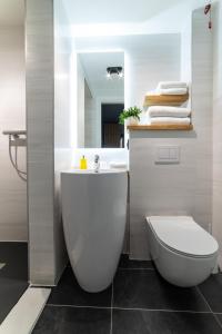 a bathroom with a white toilet and a sink at Campeador Inn in Cluj-Napoca