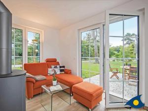 a living room with an orange couch and a patio at Fischerdorf Zirchow Käptn 12 B in Zirchow