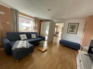 a living room with a blue couch and a chair at Ferienwohnung Rothirsch in Bad Sachsa