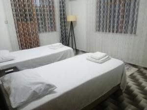 zwei Betten in einem Zimmer mit weißen Laken in der Unterkunft Daltur Cıty Apart in Dalaman