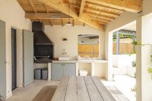 an open kitchen with a wooden table in the middle at Au Pied du Mont Ventoux in Malaucène