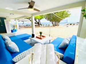 a patio with blue and white furniture on the beach at Sandcastle Villa & Beach House in The Valley