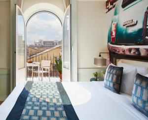 a room with a bed, a chair, and a window at Hotel Indigo Rome - St. George, an IHG Hotel in Rome