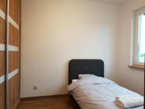 een slaapkamer met een bed in de hoek van een kamer bij Apartament Podmiejska Stargard in Stargard
