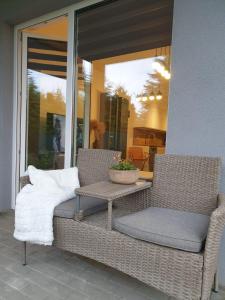 dwa wiklinowe krzesła i stół na ganku w obiekcie Apartament Podmiejska Stargard w mieście Stargard