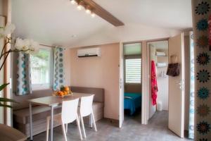 un comedor con mesa y una habitación con cocina en Vignale Resort, en Ghisonaccia