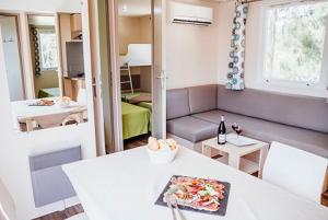 sala de estar con mesa blanca y sofá en Vignale Resort en Ghisonaccia
