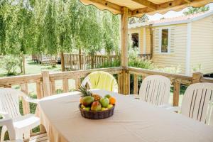 une table avec une corbeille de fruits sur une terrasse dans l'établissement Vignale Resort, à Ghisonaccia