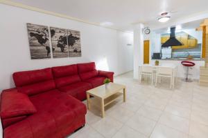 uma sala de estar com um sofá vermelho e uma mesa em Parque Del Duque em Orihuela Costa